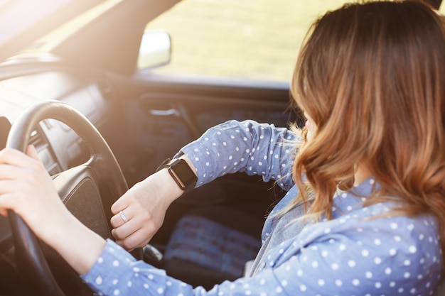 Photo of attractive female checks time on watch