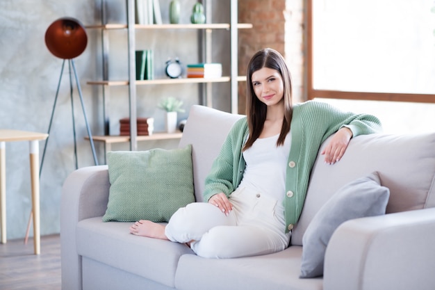 Photo of attractive girl sitting on divan in flat house