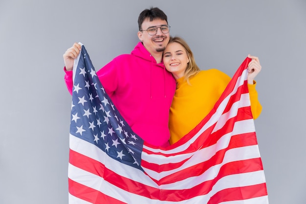 Photo of attractive multiethnic couple man and woman wrapped in american flag