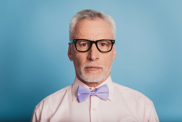 Photo of attractive serious aged man isolated on blue background