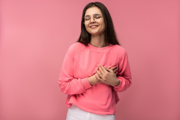 Photo of attractive young woman in glasses holds heart