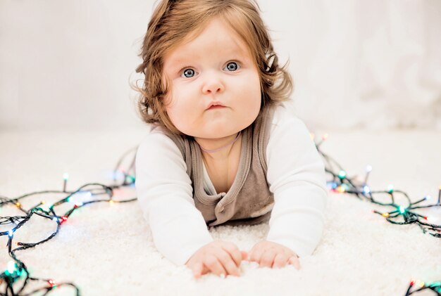 Photo of baby in the new year lights on the carpet