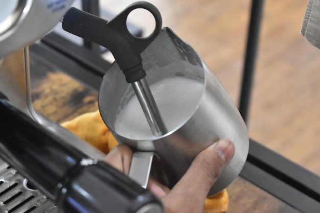 Photo photo of barista hand doing milk frothing process