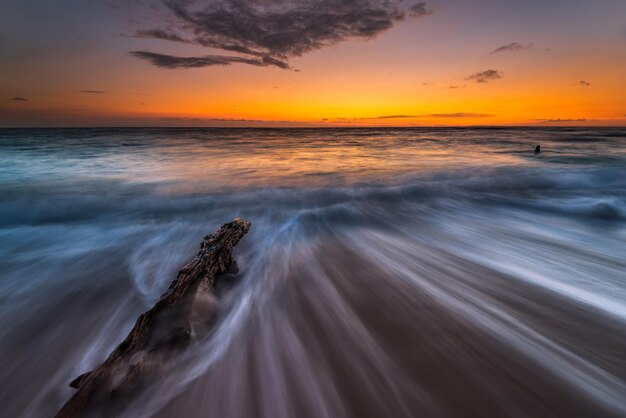 A photo of a beach with a sunset in the background