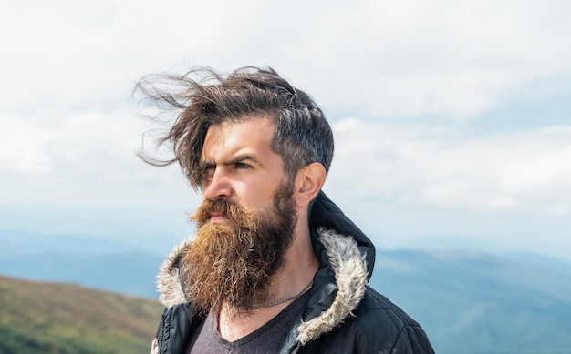 Photo of bearded brutal man in the mountain brutal man outdoor brutal man has beard