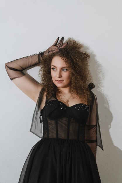 Photo of a beautiful girl in a black dress with curly hair