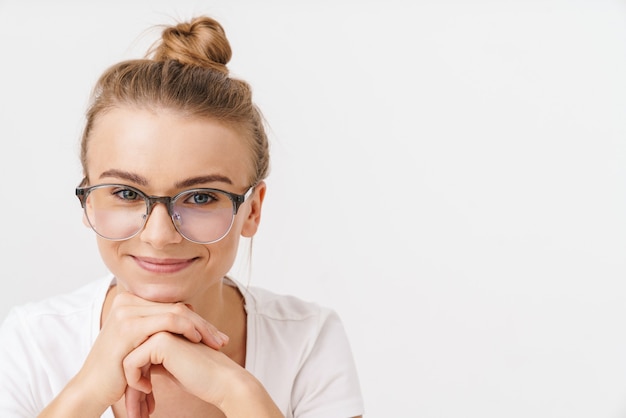 笑顔でカメラを見ている眼鏡の美しい幸せな女性の写真