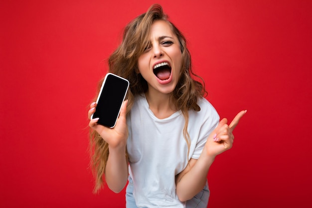 Photo of beautiful joyful smiling young blonde woman good looking wearing white tshirt standing