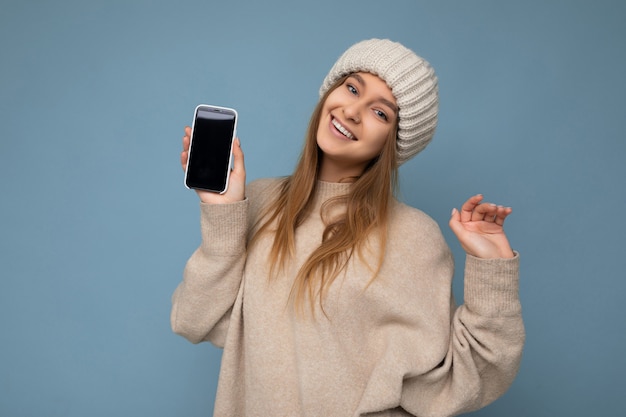 Photo of beautiful positive good looking young woman wearing stylish beige sweater and beige knitted