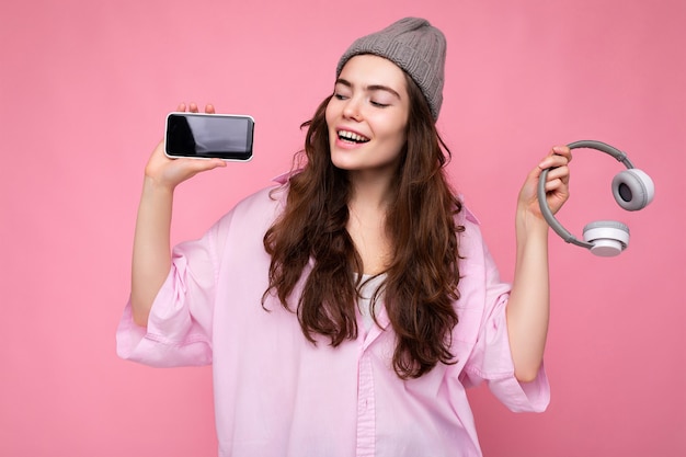 Foto di una bella giovane donna sorridente positiva che indossa un abito casual elegante isolato su colorato