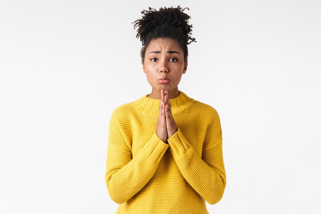 Photo of a beautiful young emotional woman posing over white wall make hopeful please gesture.