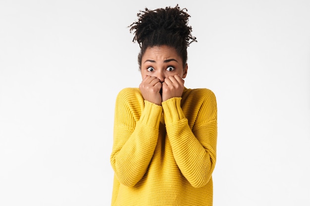 Photo of a beautiful young scared woman posing over white wall covering face.