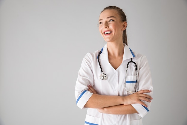 Foto di un medico cosmetologo giovane e bella donna isolato sopra il muro grigio.