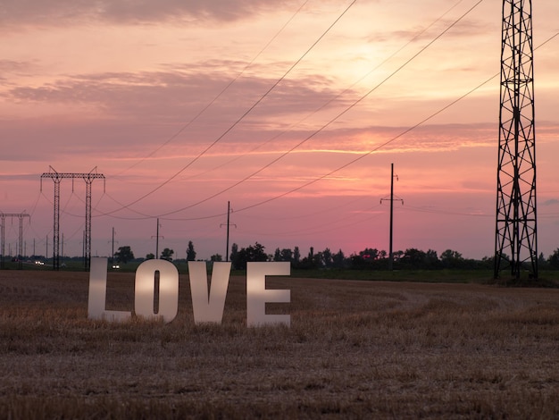 Photo of big white letters with foam on background of sunset in nature