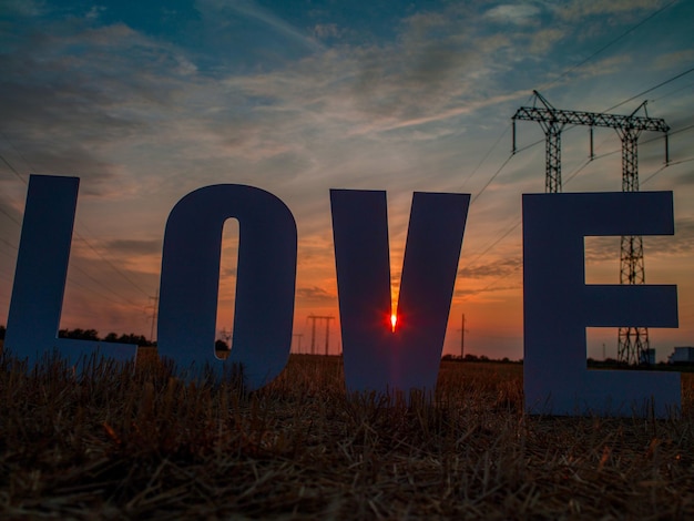 Photo of big white letters with foam on background of sunset in nature