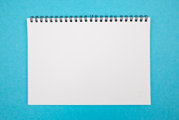 Photo of a blank white notepad on an isolated blue background copy space