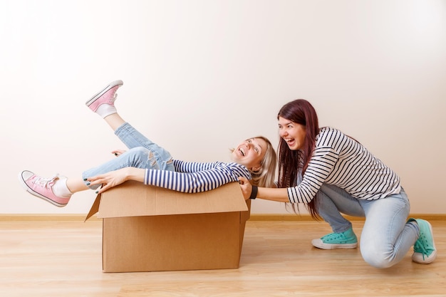 Photo of blonde in cardboard box and brunette