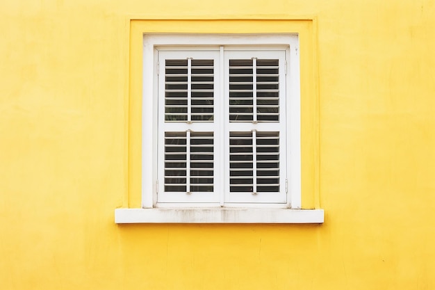 Photo photo blue orange and yellow wooden window is classic vintage style on white cement wall background