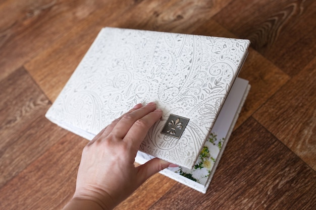 Photo book with a cover of genuine leather. White color with decorative stamping. Hand opening photo book