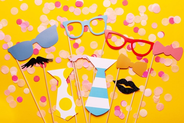 Photo booth props glasses, mustache, lips on a pink background flat lay. Birthday parties and weddings.