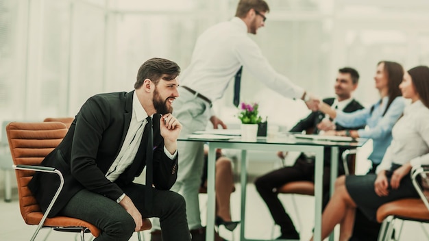 Photo of the boss on the background of handshake of a Manager with a client in the workplace in a modern office.the photo has a empty space for your text