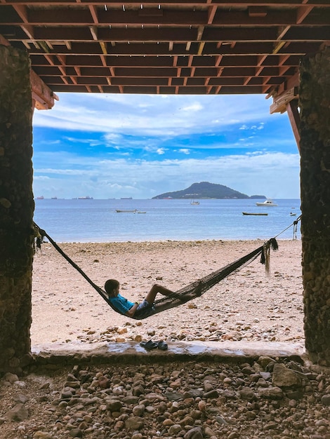 Foto foto di un ragazzo su un'amaca vicino al mare foto