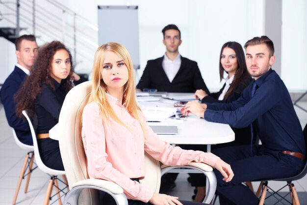 Photo of business woman with her staff in conference room at the meeting