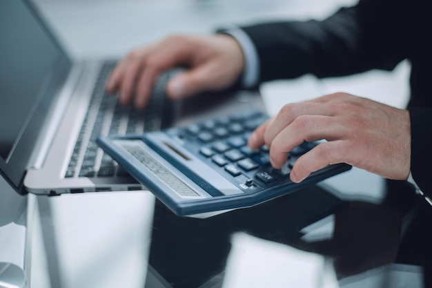 Photo of businesspersons hand calculating invoice with calculator