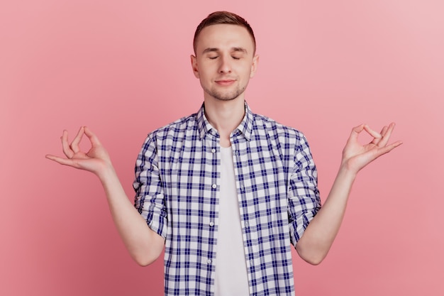 Photo of calm peaceful attractive young man make hands om gesture yoga isolated on pink color background