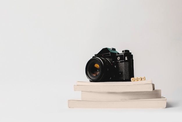 Photo camera on books isolated on white