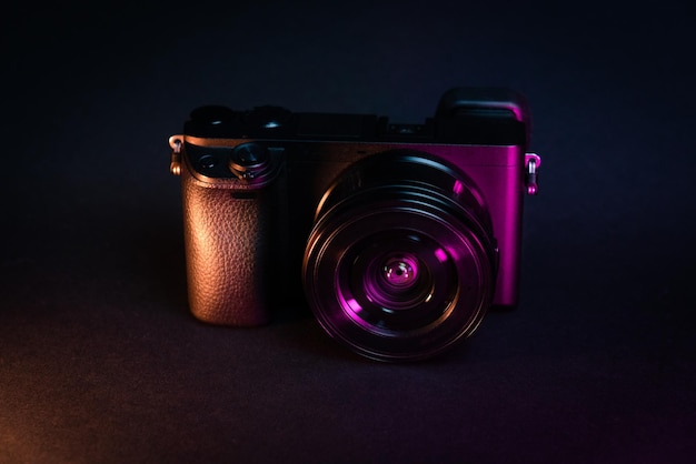 Photo camera on dark background Neon color lights Front view studio shot