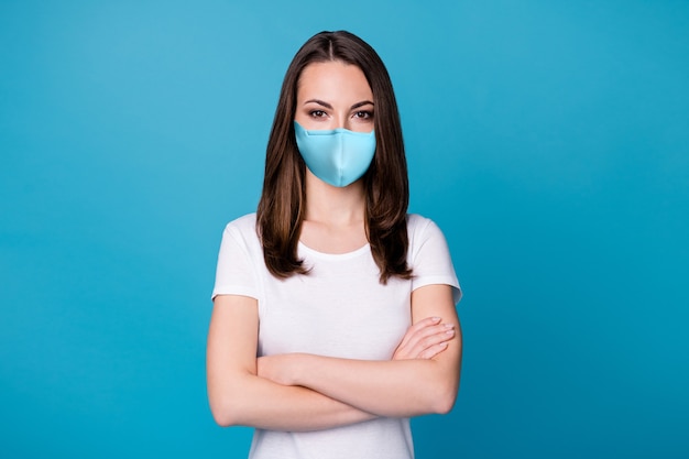 Photo of charming confident lady arms hands crossed bossy
worker intelligent person successful career team member wear casual
medical mask white t-shirt isolated blue color background