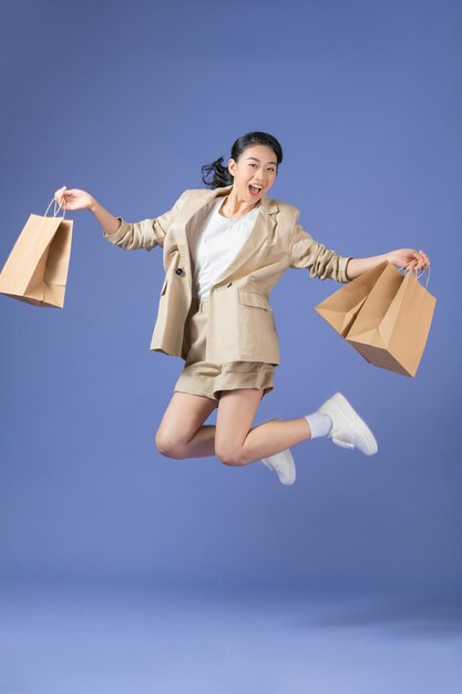 Photo of charming funny young lady smiling holding bargains walking jumping isolated purple color background