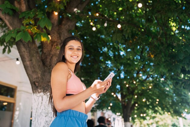 Photo of charming pretty young lady communicating modern gadget