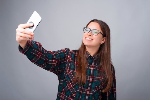 Photo of charming young woman taking selfie with smartphone