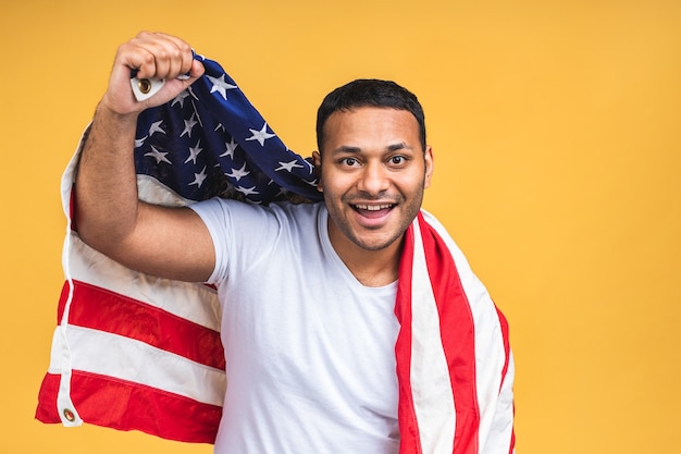 쾌활한 미국 흑인 인도 남성 시위자가 미국 국기를 들고 흑인 혁명을 사랑하는 사진은 모든 인간이 노란색 배경 위에 고립된 단결 연대를 표현합니다.