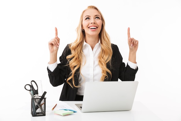 Photo of cheerful businesswoman sitting at workplace and working on laptop, isolated