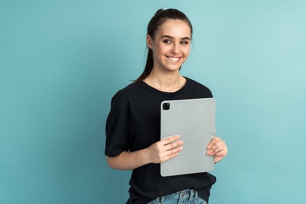 Photo of cheerful cute nice charming girl holding tablet