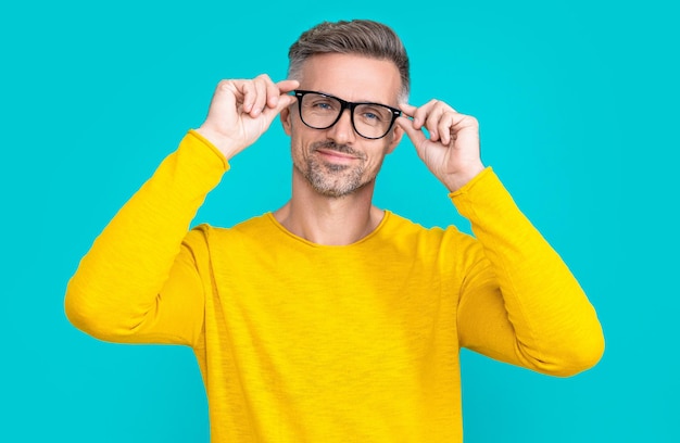 Photo of cheerful man look in eyewear man look in eyewear isolated on blue