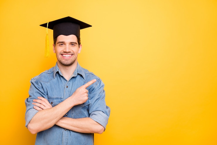 Photo photo of cheerful positive handsome smiling toothily pointing at empty space with hands folded wearing cap isolated vivid color wall