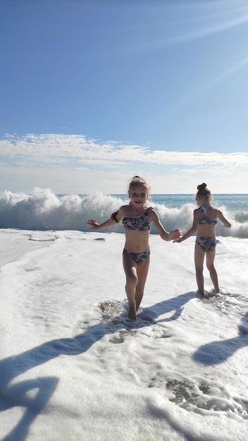 photo of children on the background of the sea with big waves