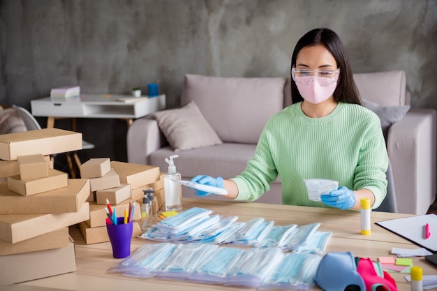 Foto della signora cinese mani guanti in lattice affari organizzare ordine viso maschere mediche pacchetto fatto a mano smistamento scatole di cartone consegna online negozio direttore commerciale ufficio a casa al chiuso