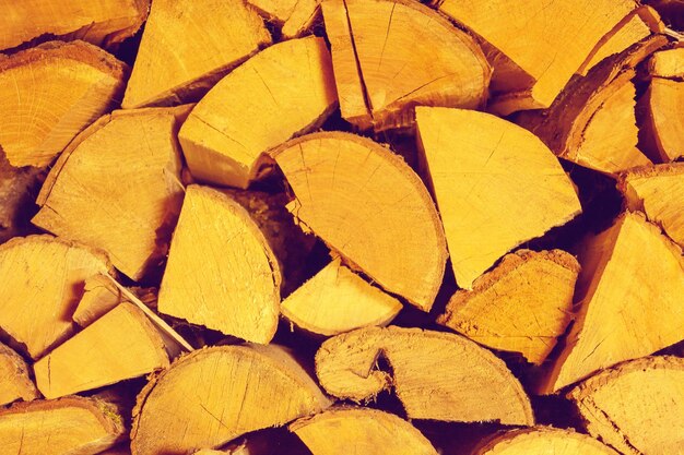 Photo of chopped firewood texture in warm orange tone