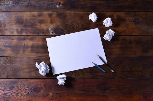 Photo of a clean white blank sheet of paper lie on a brown 