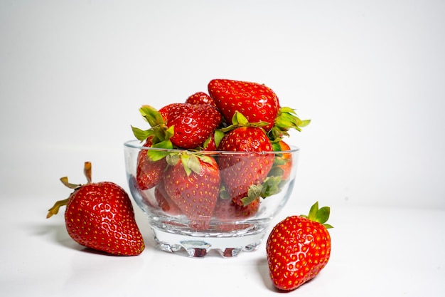 흰색 backgr에 신선하고 맛있는 딸기로 가득 찬 투명한 그릇의 사진 클로즈업 샷