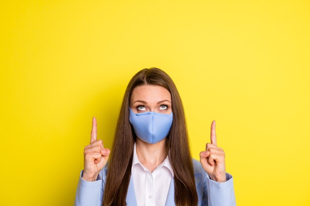 Photo of collar girl point index finger copyspace demonstrate covid quarantine news wear blue blazer suit respiratory mask isolated over bright shine color background