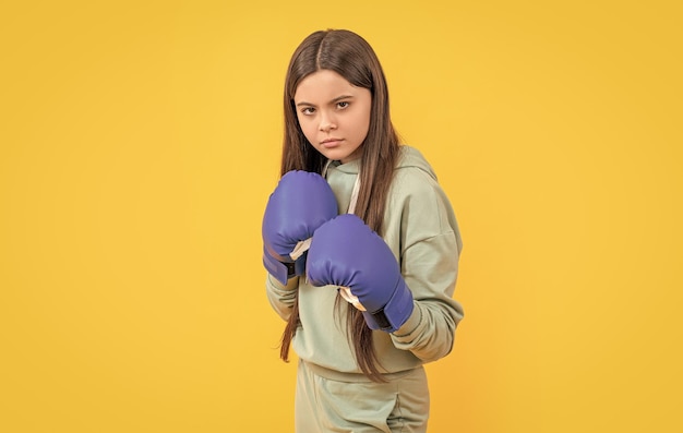 photo of concentrated teen boxing girl wearing gloves teen boxing girl isolated on yellow teen boxing girl in studio teen boxing girl on background