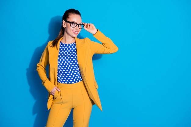 Photo of confident cool pretty magnificent gorgeous lady boss look copyspace ready decide work decision touch spectacles wear yellow pants trousers isolated blue color background