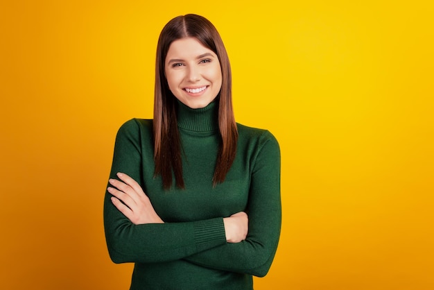 Foto di una signora positiva fiduciosa con le braccia conserte sorriso splendente indossa una camicia verde isolata su sfondo giallo