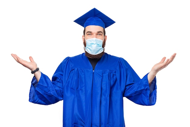 Photo of confused student man wearing graduating hat and bachelor and wearing facial mask